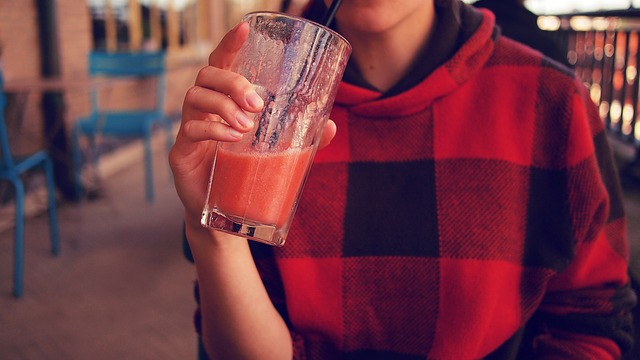 teenager držící nápoj v proužkované mikině